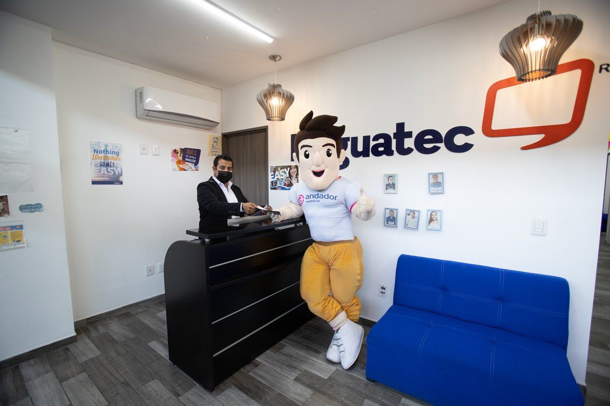 Una mascota está parada frente a un mostrador en un vestíbulo.