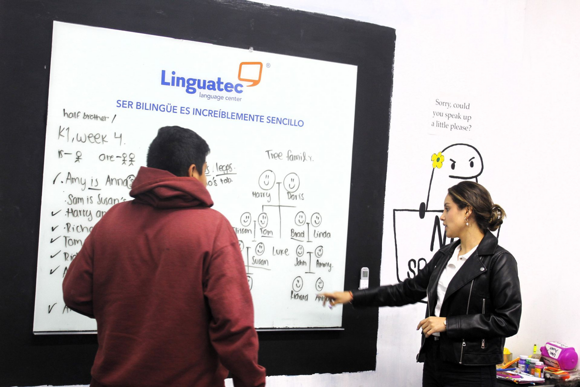 Un hombre y una mujer están parados frente a una pizarra.