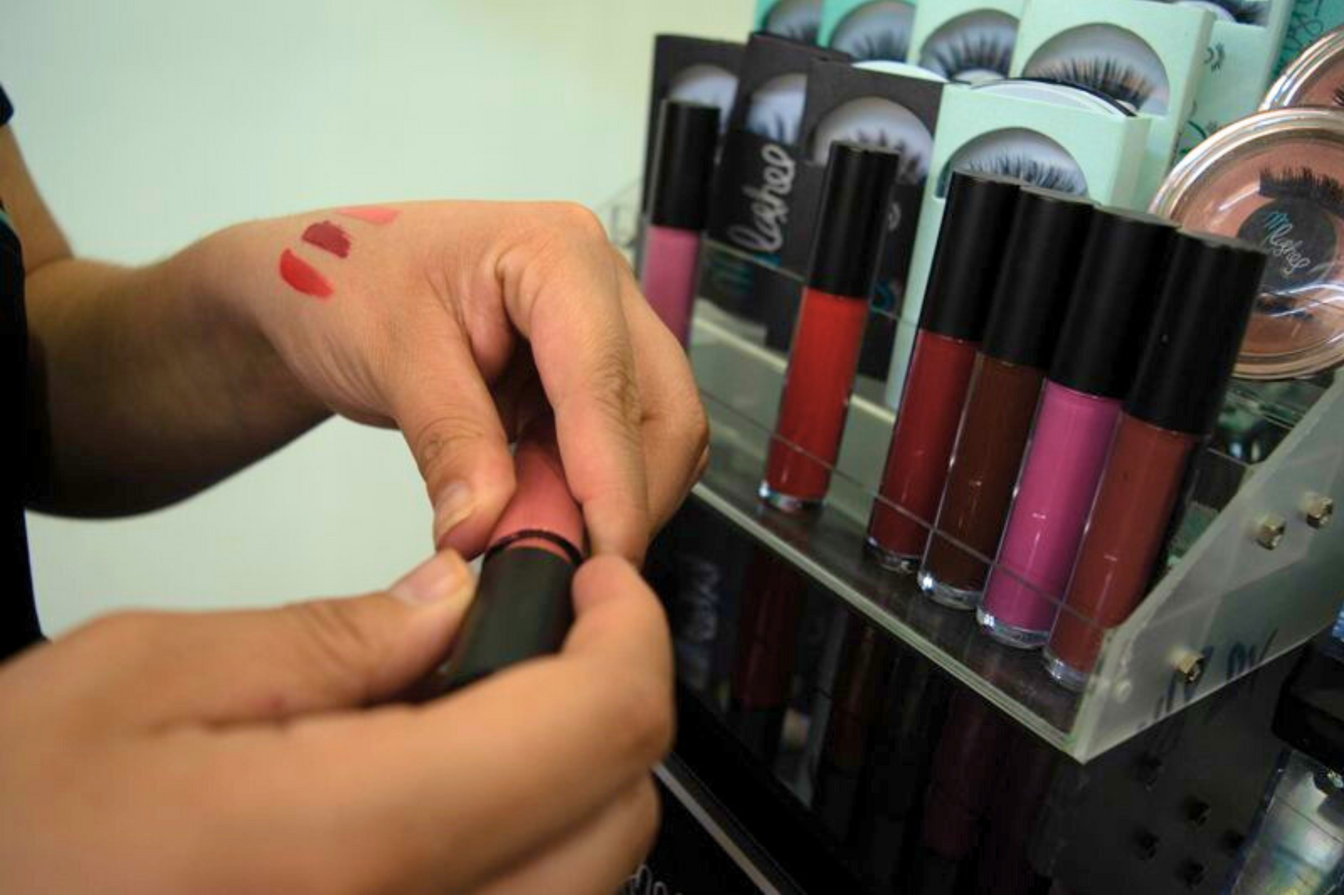 Una persona con un tatuaje en el brazo se aplica lápiz labial