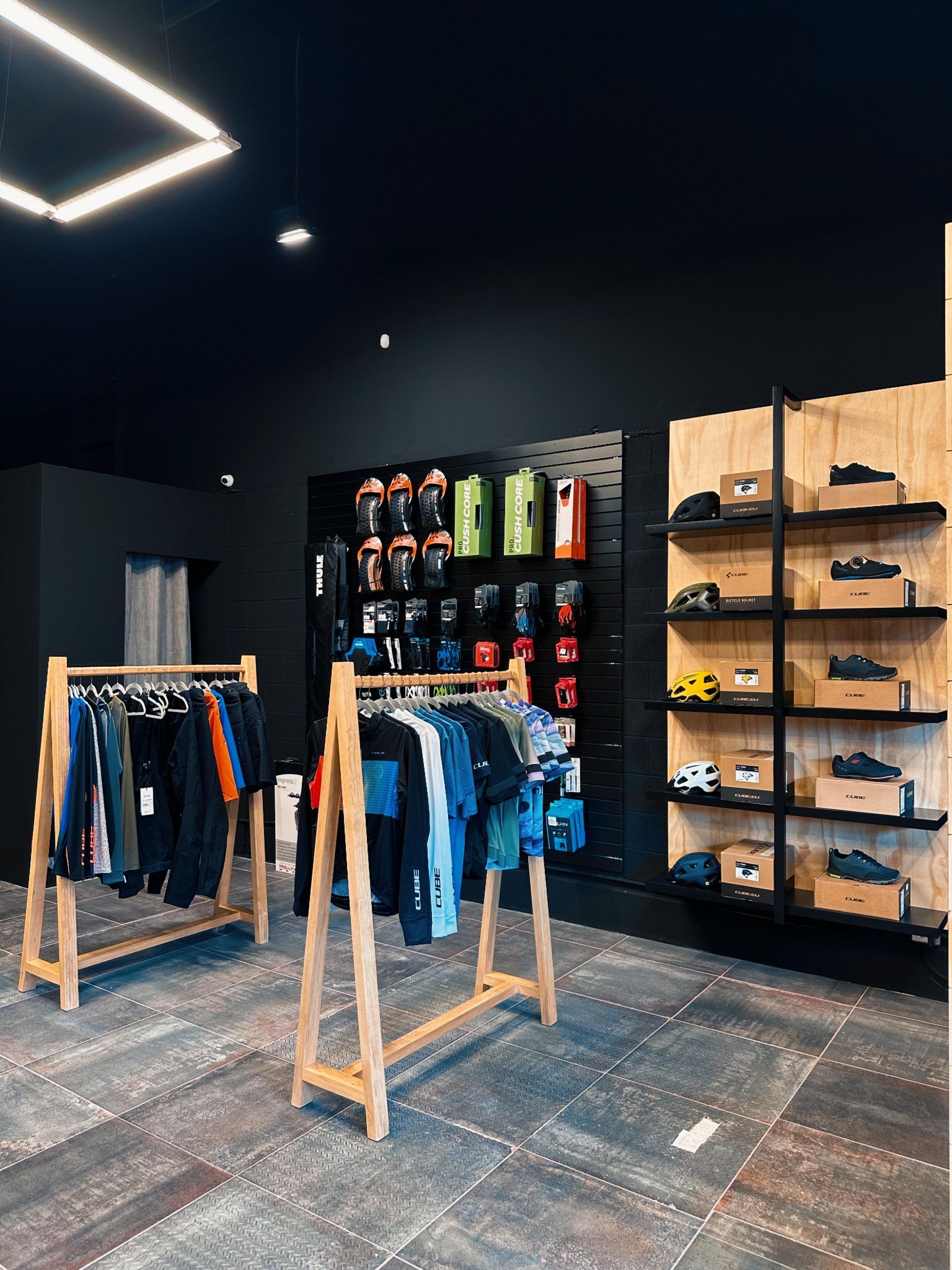 Una tienda con ropa colgada en percheros y estanterías.