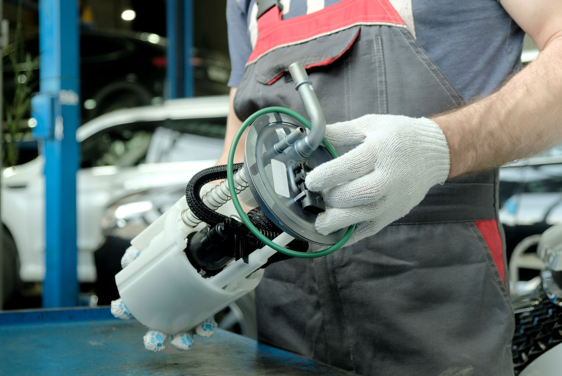 A man is holding a fuel pump in his hands | Cosmo's Service Center