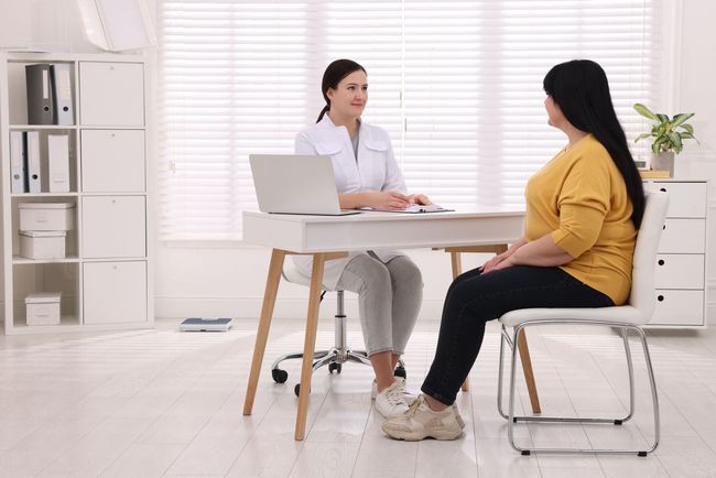 A woman is getting her face examined by a doctor.