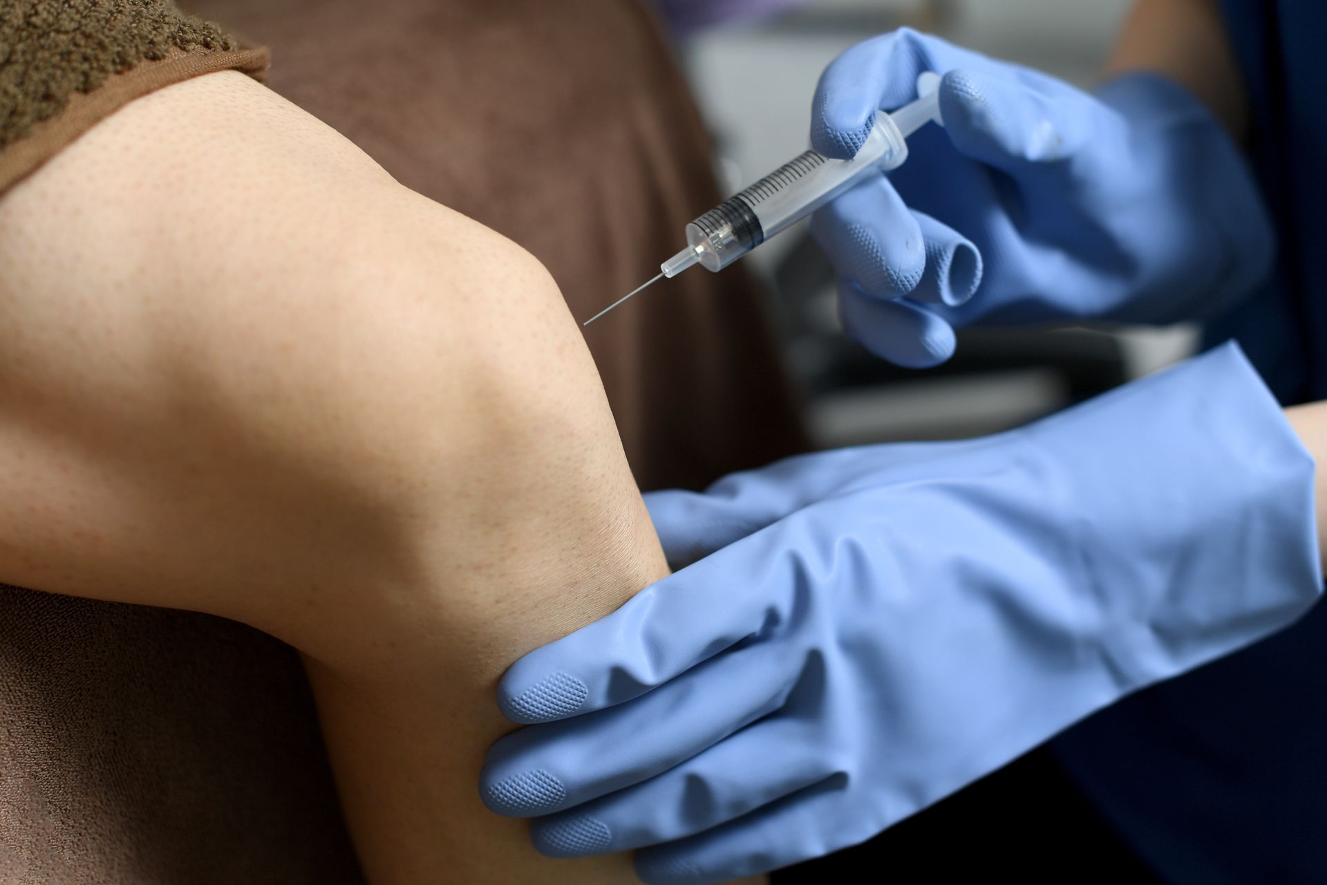 A person is getting an injection in their knee.