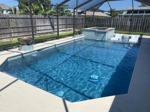 A large swimming pool in a backyard with a screened in area.