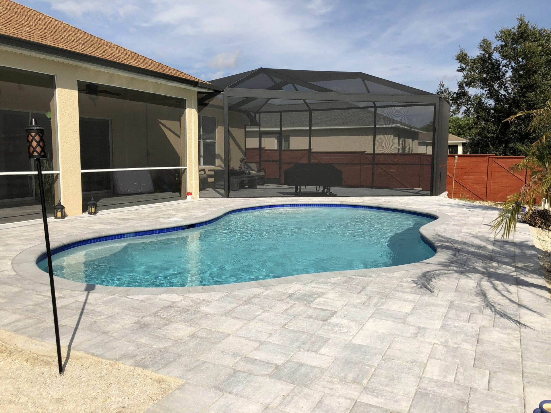 A large swimming pool is in the backyard of a house.