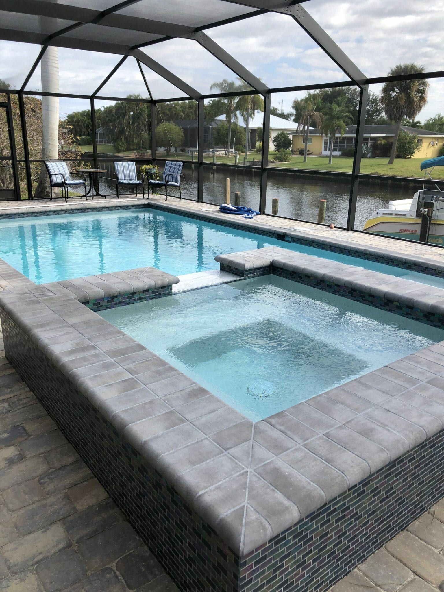 A large swimming pool with a hot tub in the middle of it.