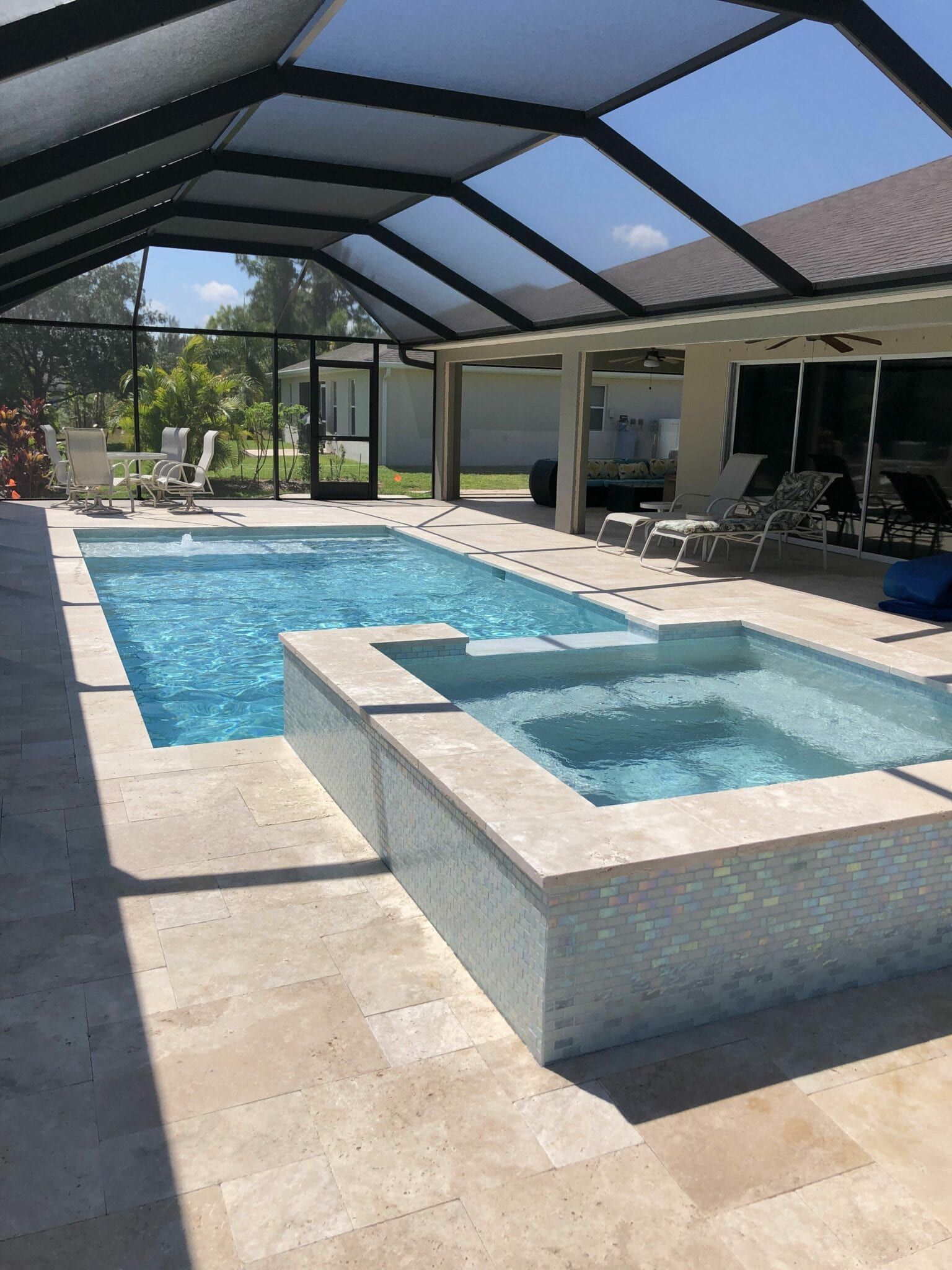 There is a large swimming pool and a hot tub in the backyard built by Into h2o Pools & Spas Cape Coral