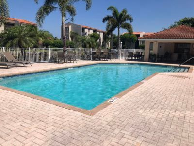 A large swimming pool with palm trees in the background
