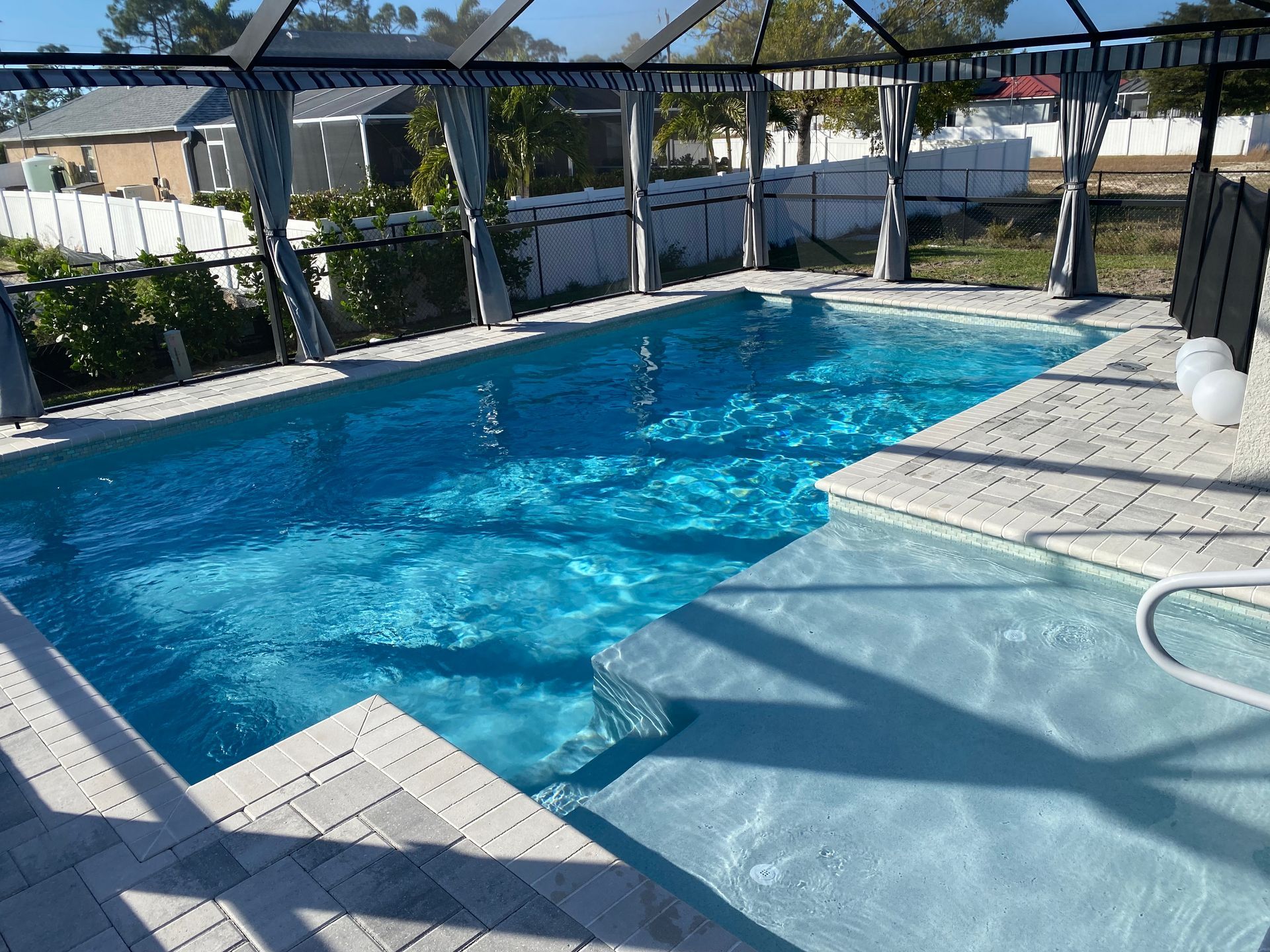 A large swimming pool with a canopy over it built by Into h2o Pools & Spas Cape Coral