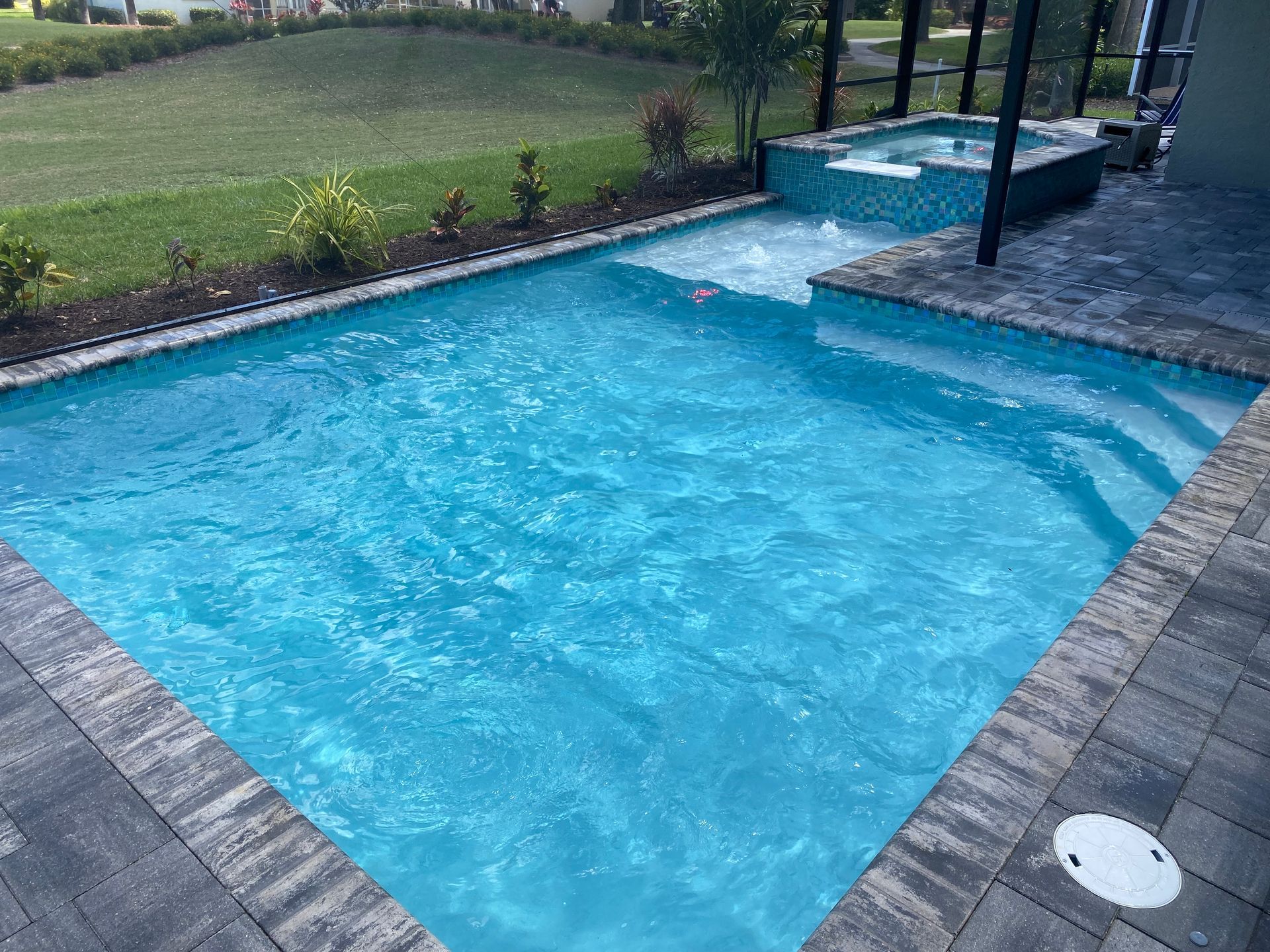 A large swimming pool with a hot tub in the backyard built by Into h2o Pools & Spas Cape Coral