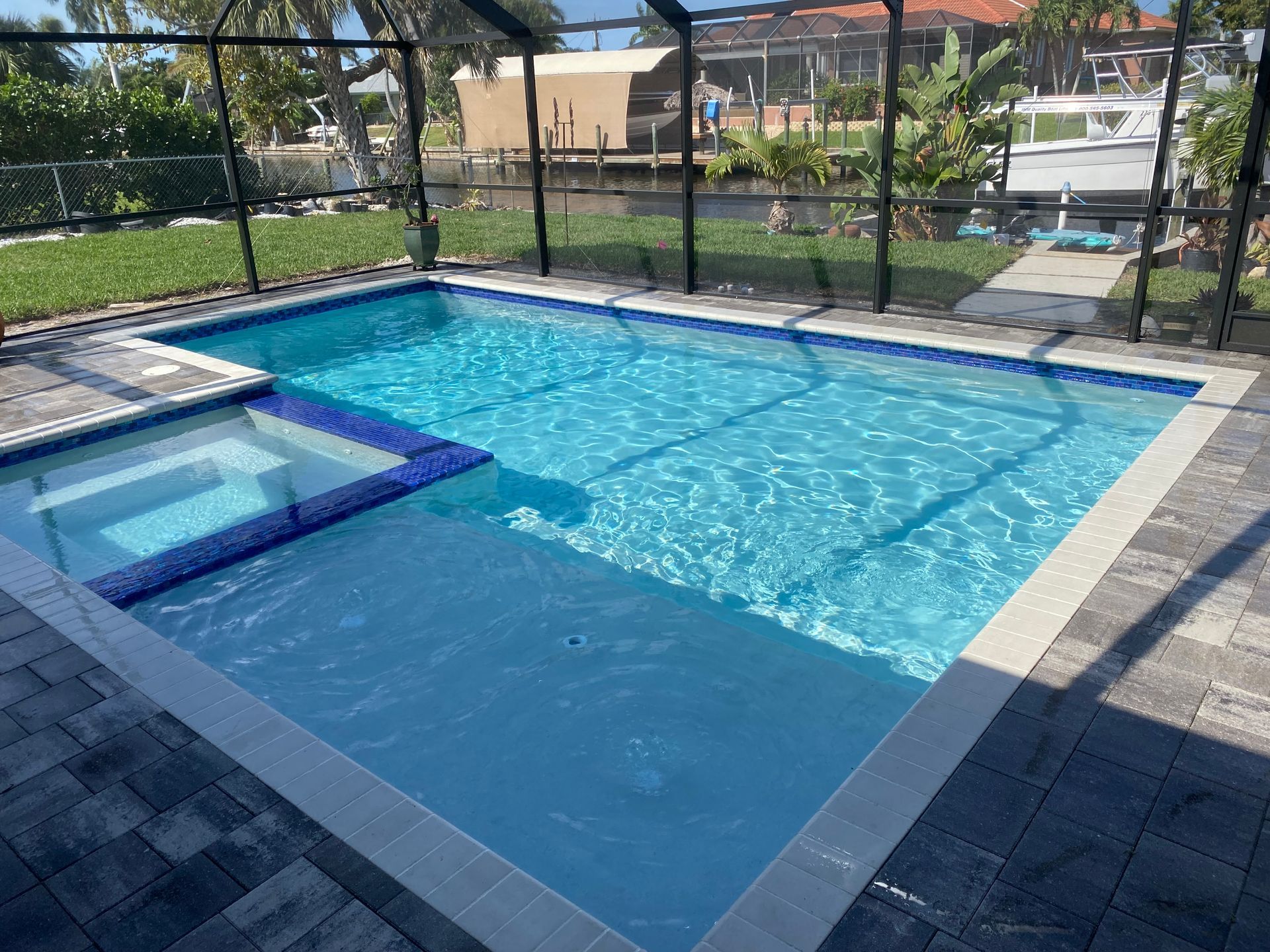 A large swimming pool with a hot tub in the backyard built by Into h2o Pools & Spas Cape Coral