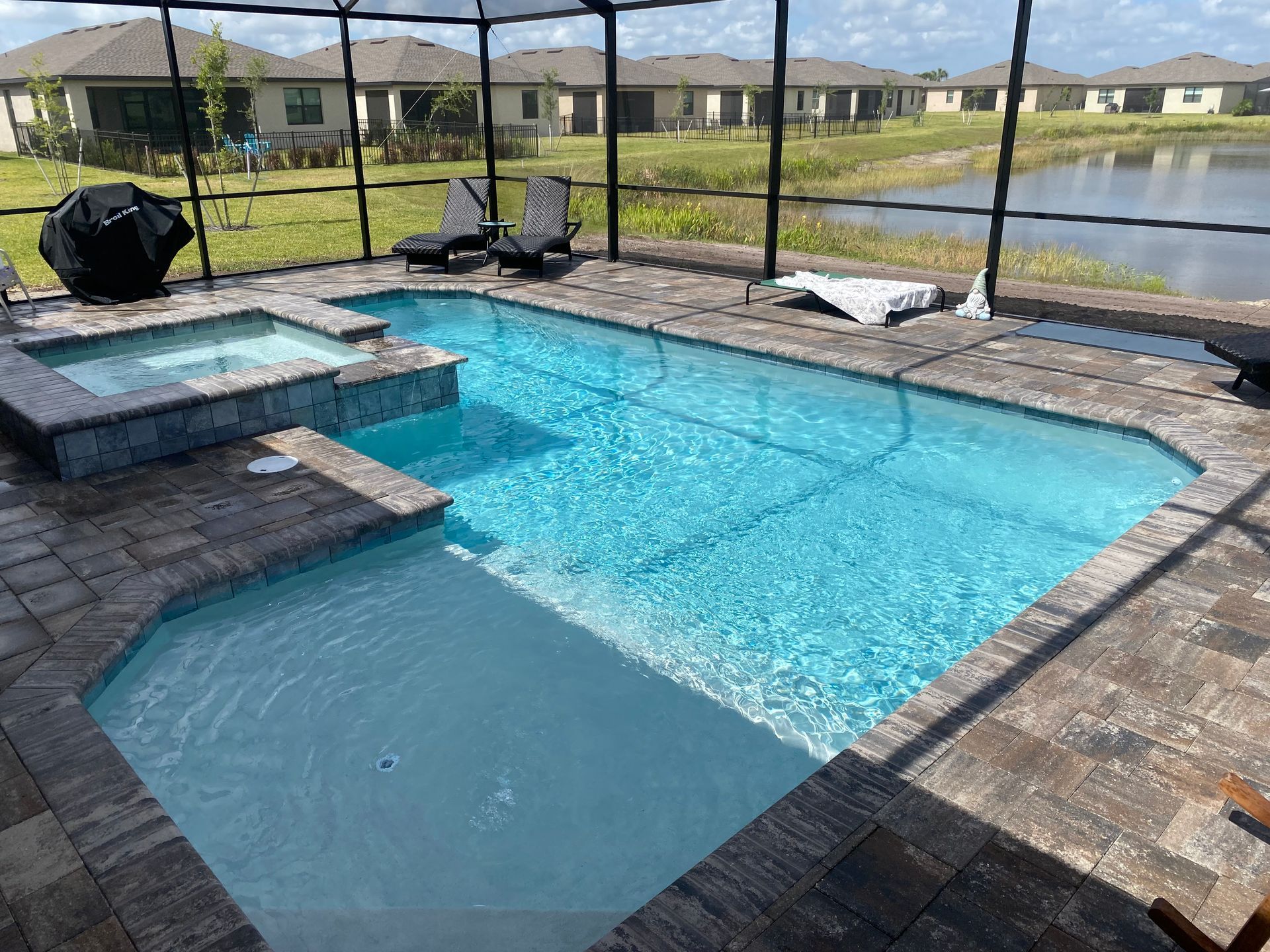 A large swimming pool with a jacuzzi next to it.