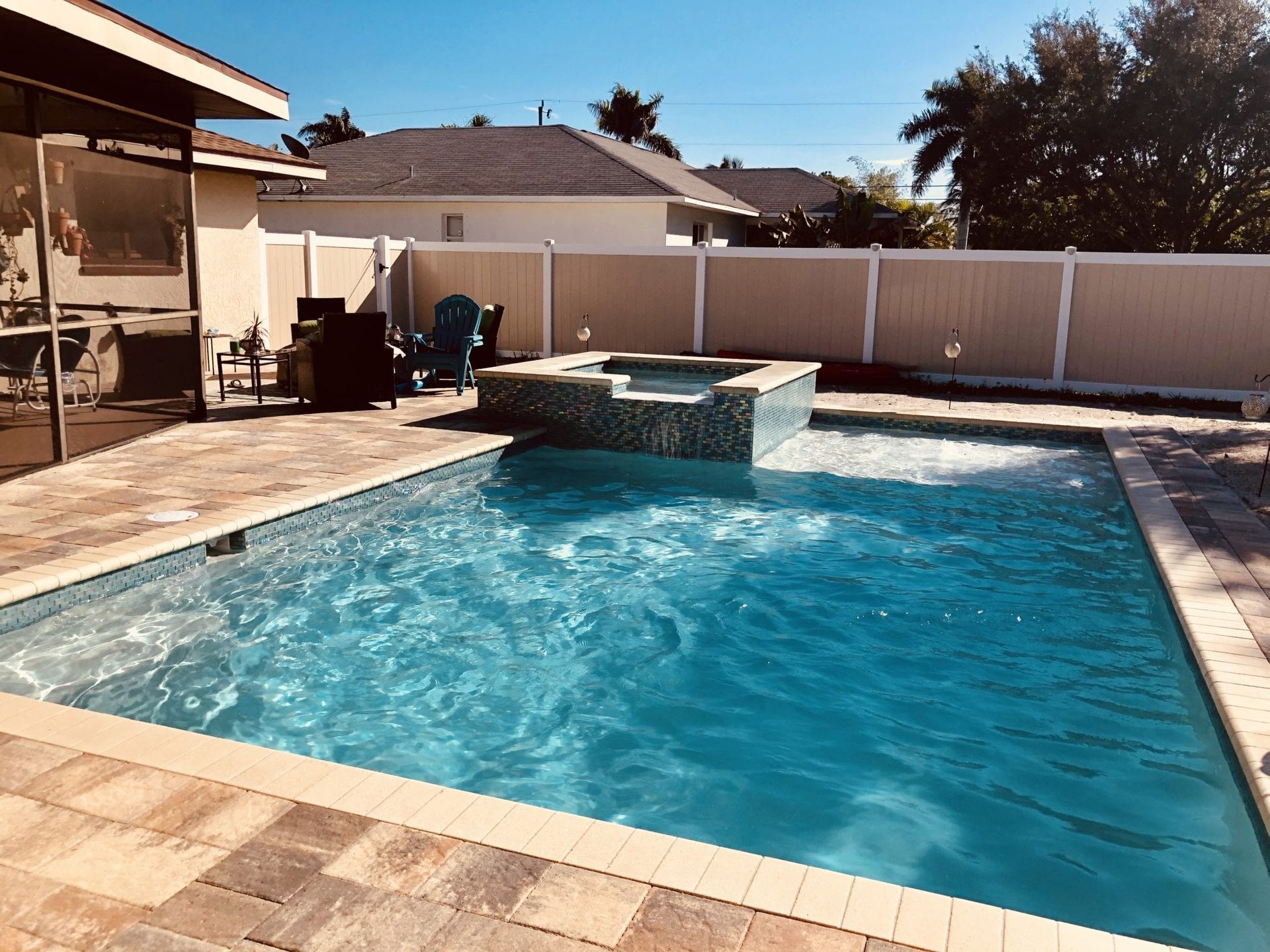 There is a large swimming pool in the backyard of a house built by Into h2o Pools & Spas Cape Coral