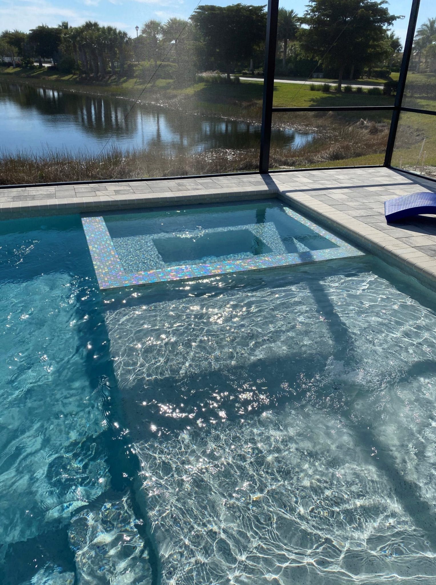 A large swimming pool with a view of a lake.