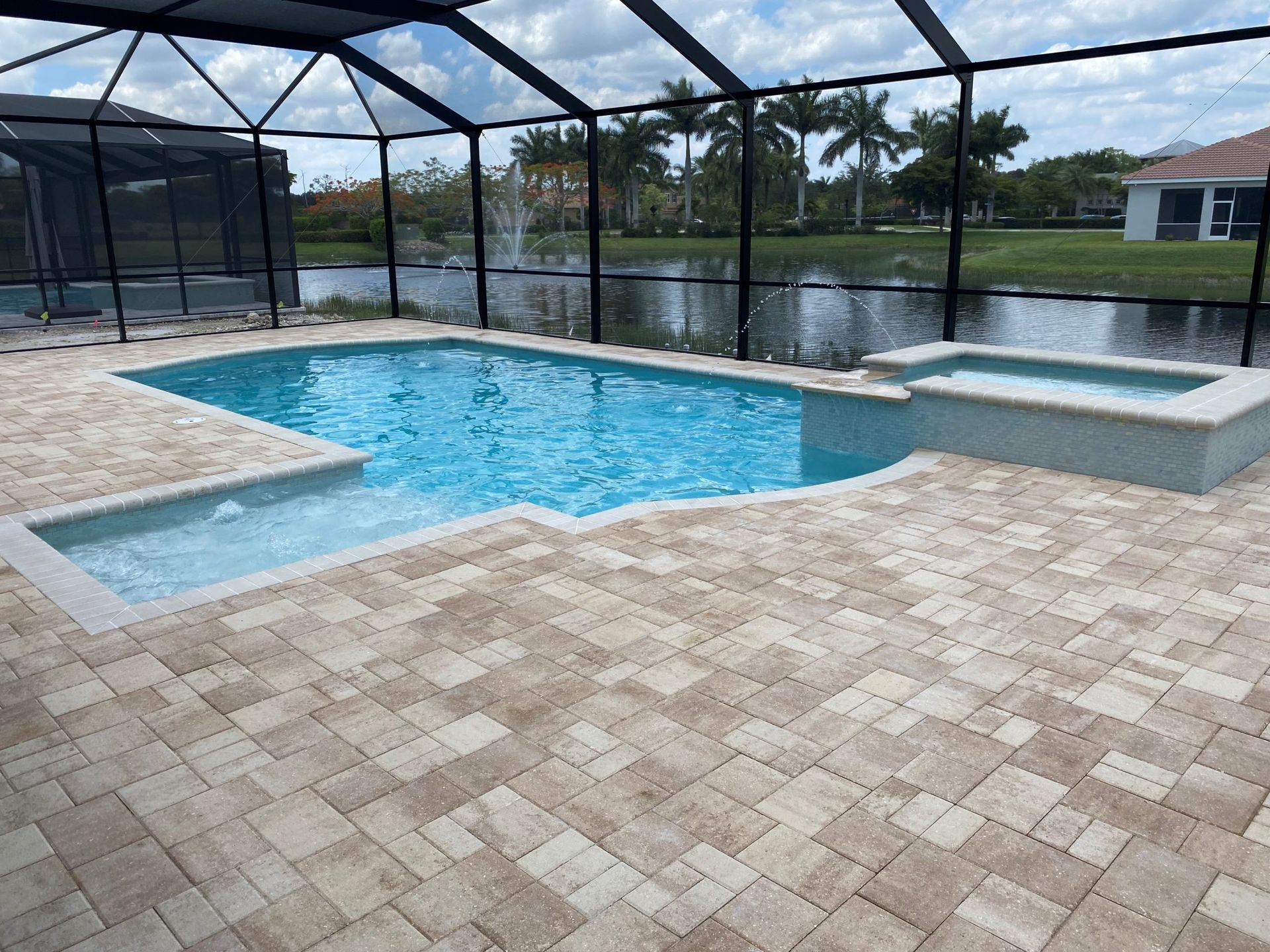 A large swimming pool is surrounded by a screened in area built by Into h2o Pools & Spas Cape Coral