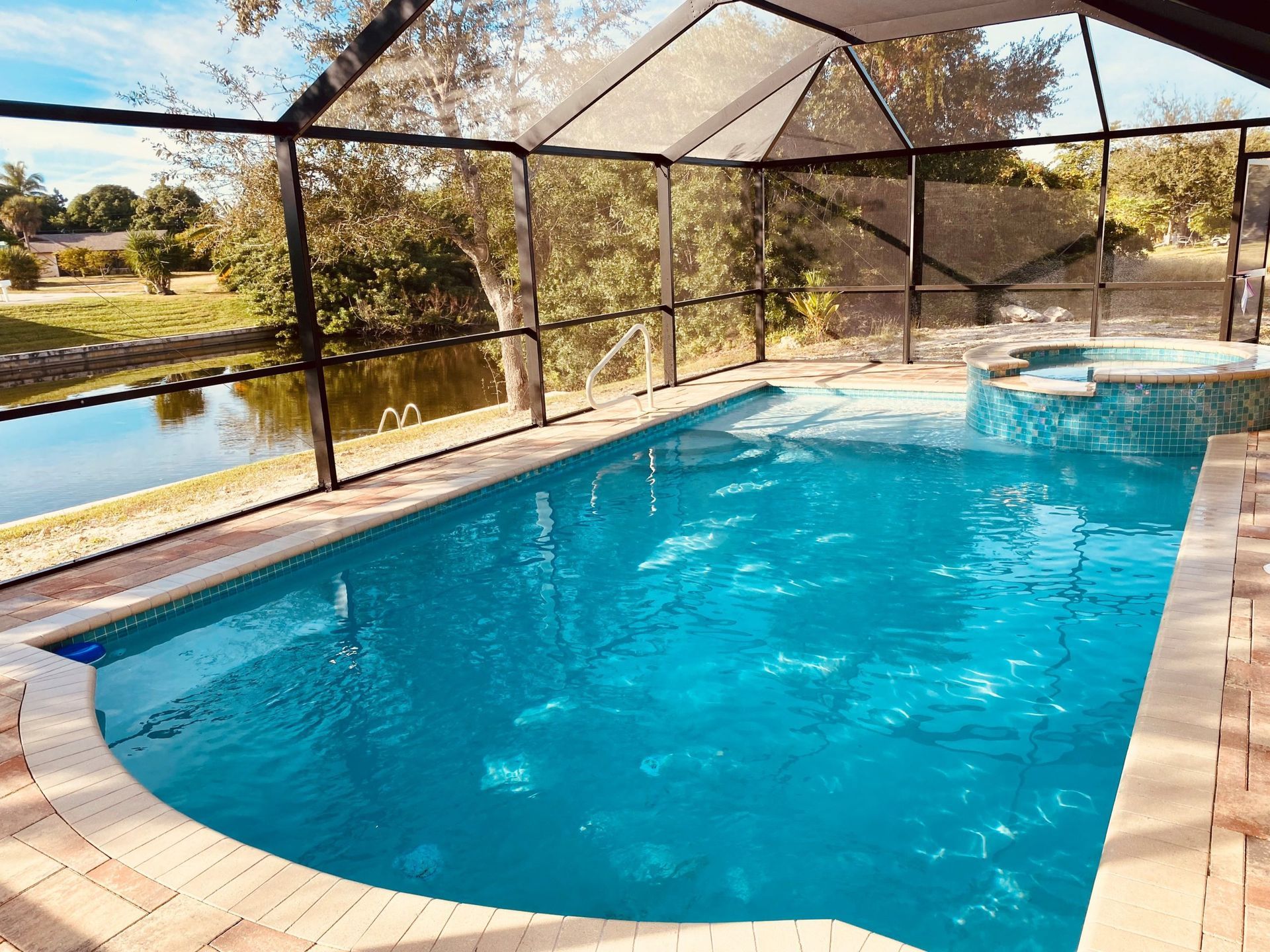 A large swimming pool with a view of a lake built by Into h2o Pools & Spas Cape Coral
