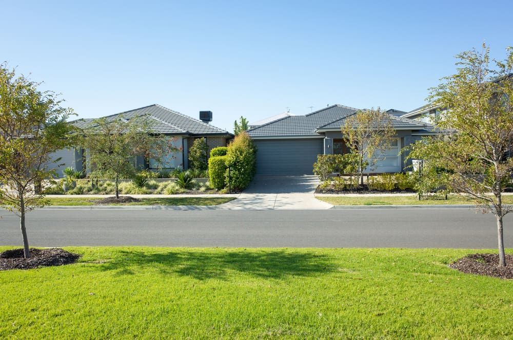 Two Modern Houses With Gray Roofs and a Driveway — Frosty Solutions Air Conditioning In Ulan, NSW