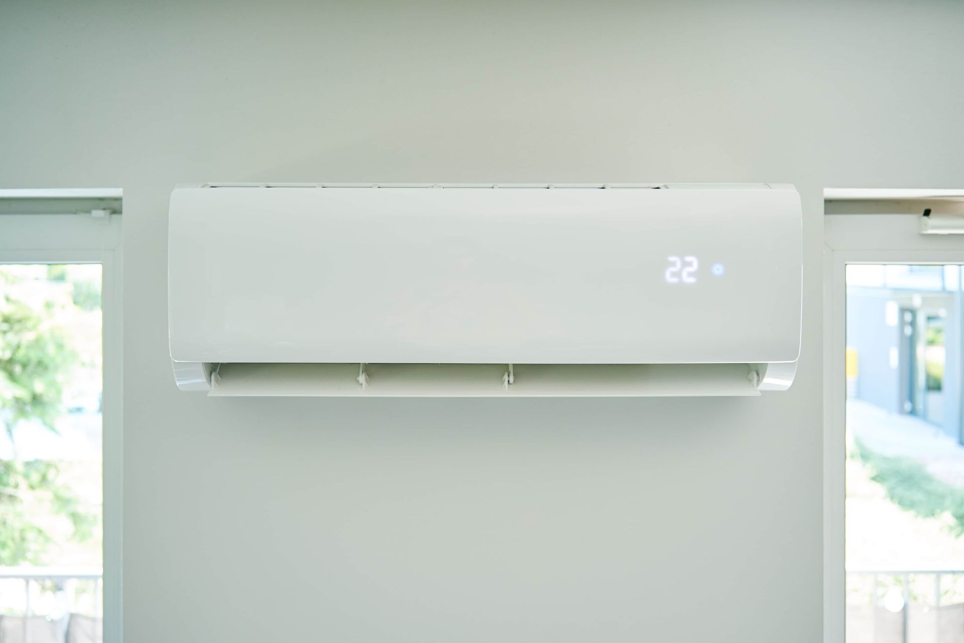 White Air Conditioner Mounted on a Gray Wall — Frosty Solutions Air Conditioning In Ulan, NSW