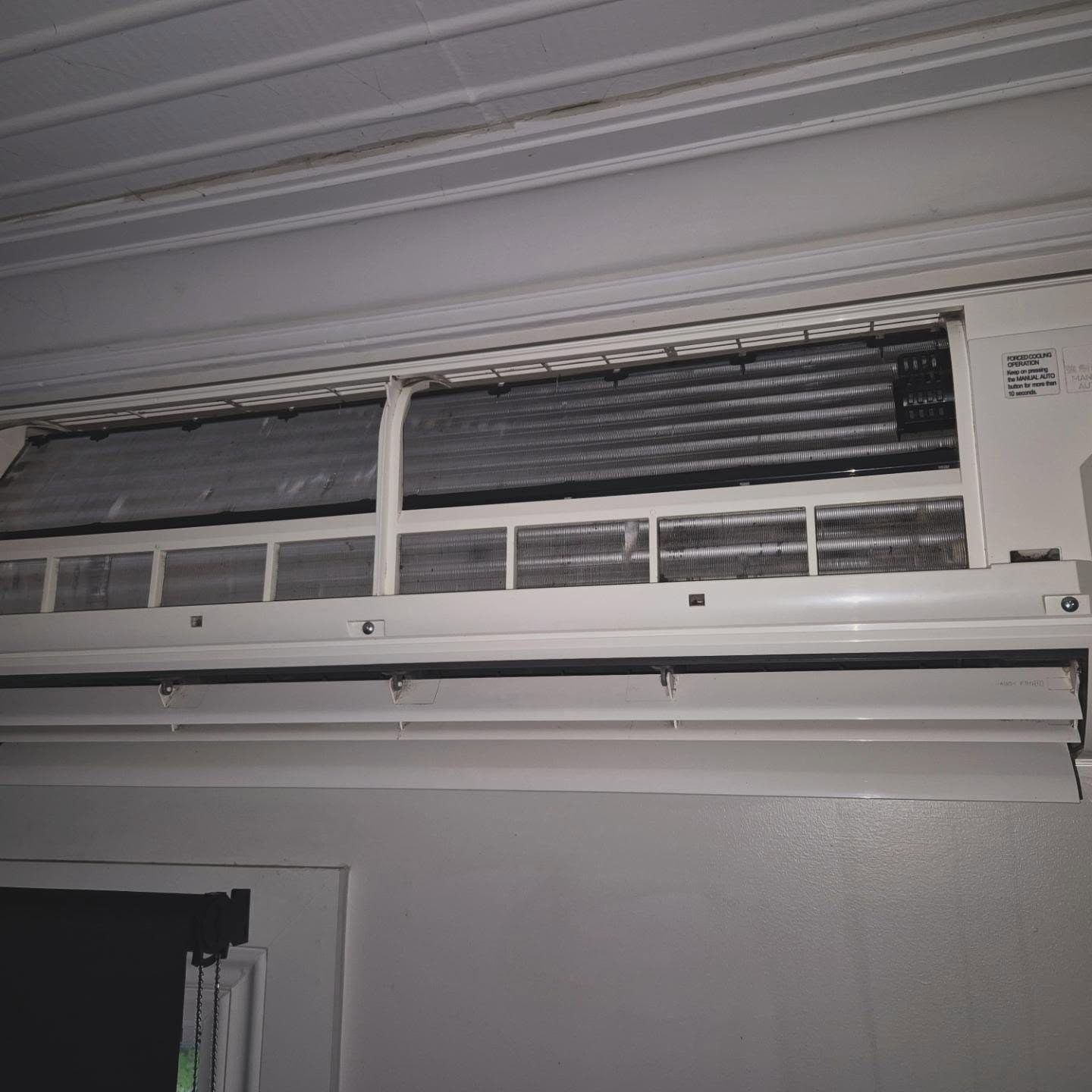 White Air Conditioning Unit Mounted on a Wall With Dusty Coils Visible — Frosty Solutions Air Conditioning In Mudgee, NSW