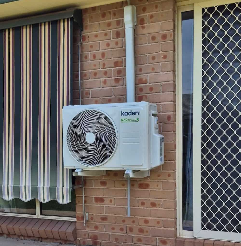 An Air Conditioner Unit Mounted on a Brick Wall — Frosty Solutions Air Conditioning In Rylstone, NSW