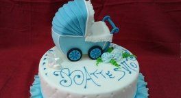 una torta a due piani con sopra un disegno di un carrozzino