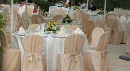 dei tavoli apparecchiati e decorati con dei fiori per una cerimonia