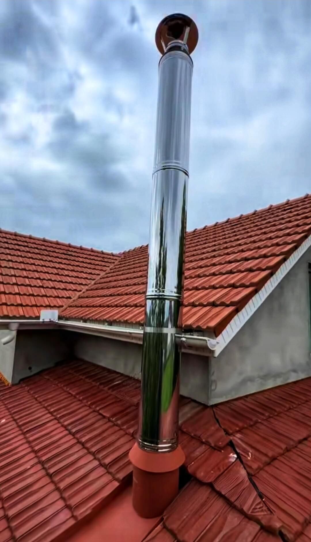 Un camino è posizionato in cima a un tetto di tegole rosse.