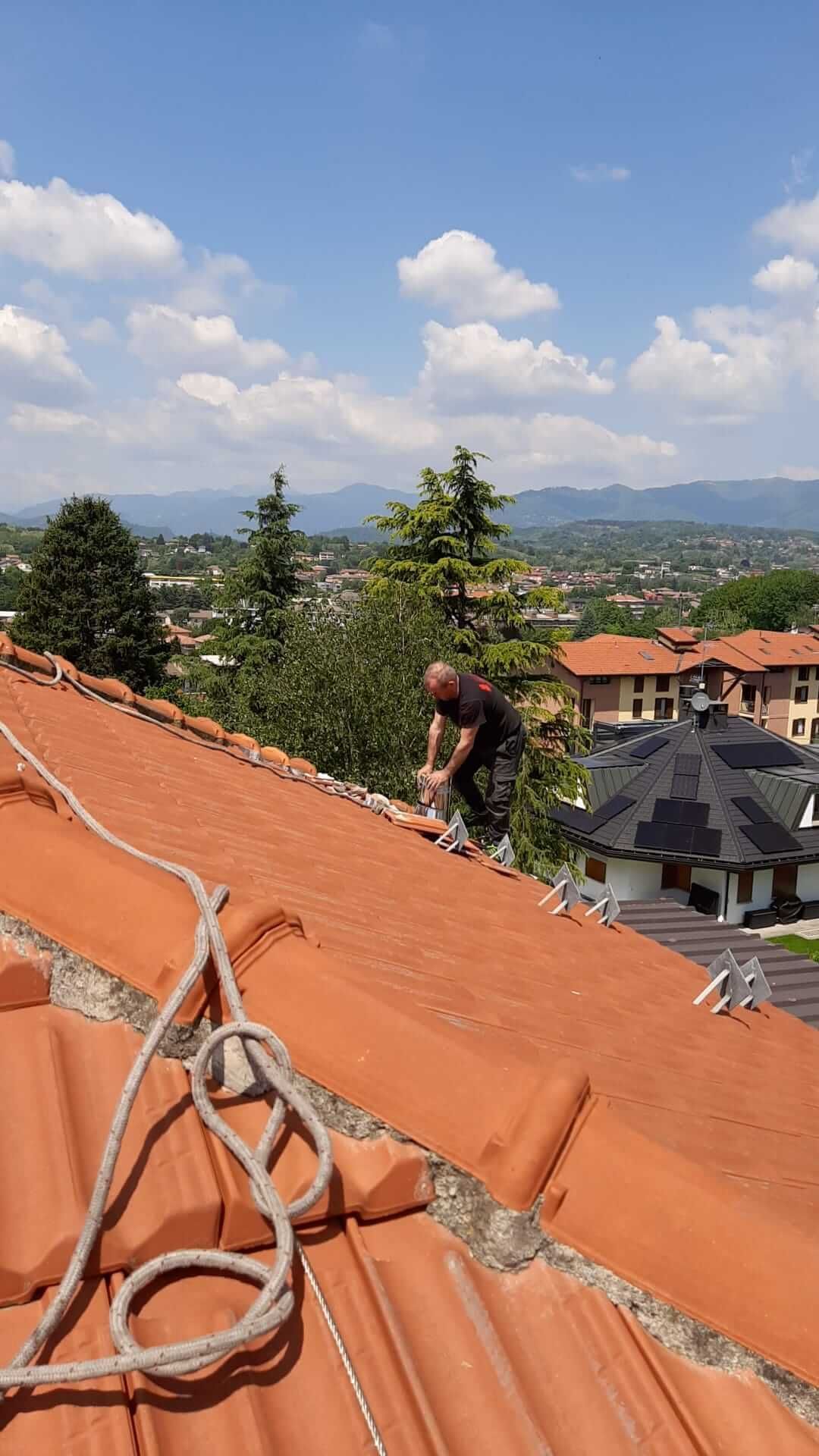 spazzacamino sta lavorando sul tetto di una casa per istallazione canna fumaria