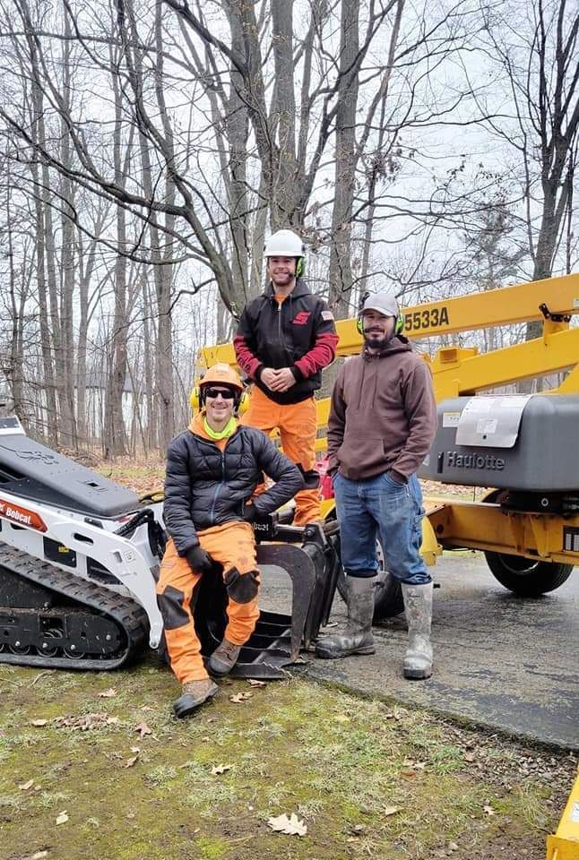 Three men are posing for a picture next to a bulldozer.