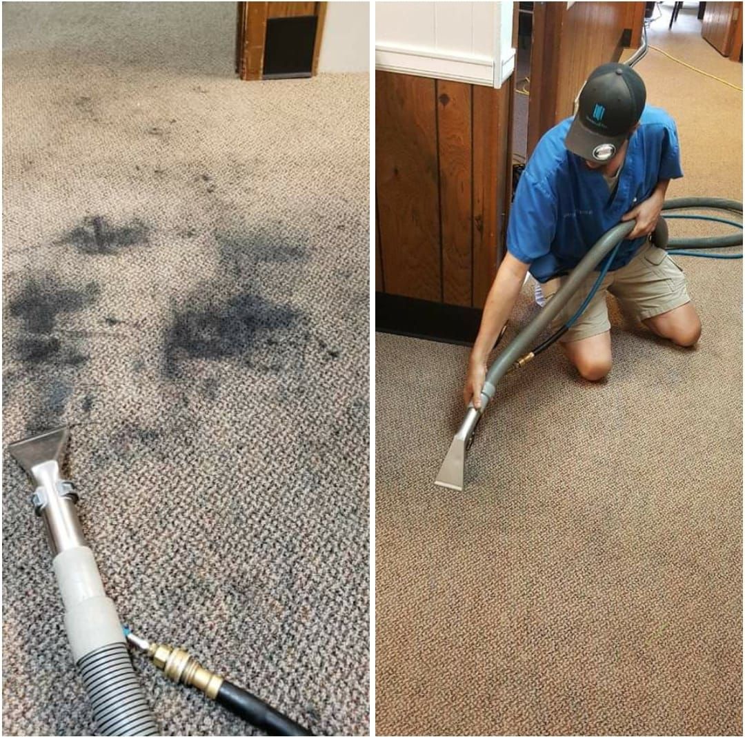 A man is cleaning a carpet with a vacuum cleaner.