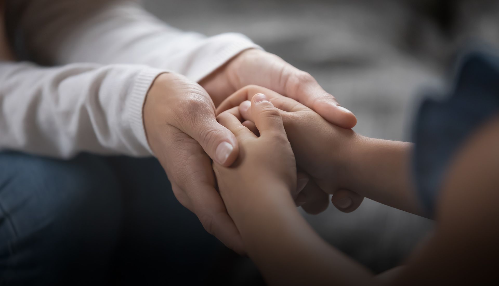 A close up of a person holding a child 's hand.