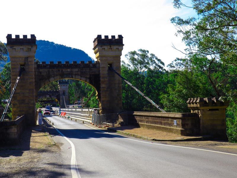 Castle Style Bridge Post With A Four Wheeler Coming Through It — Bridge Plumbing & Trades in Berry, NSW