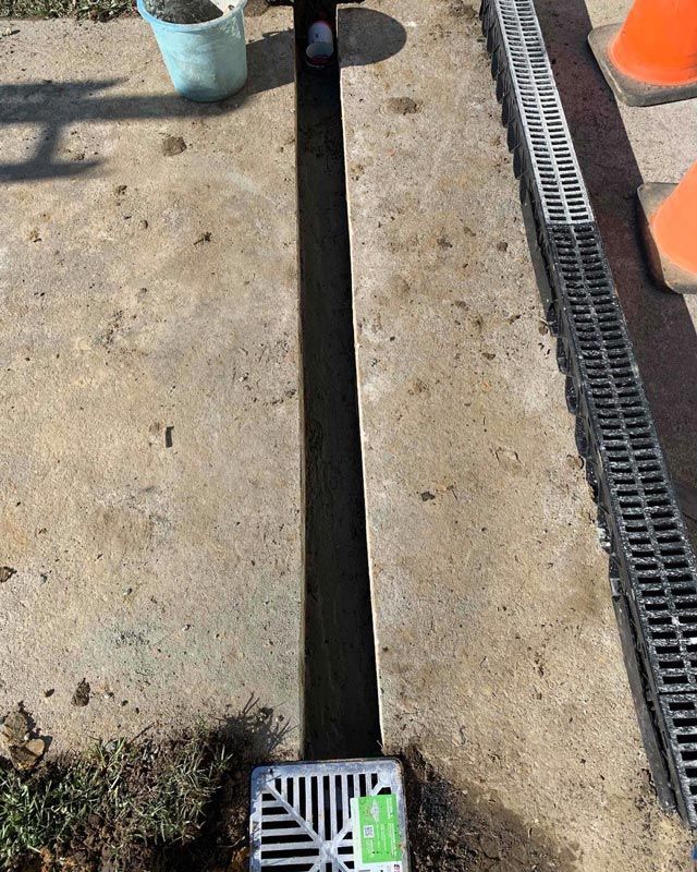 A Drainage System Outdoor With A Drainage Grill On Right — Bridge Plumbing & Trades in Nowra, NSW