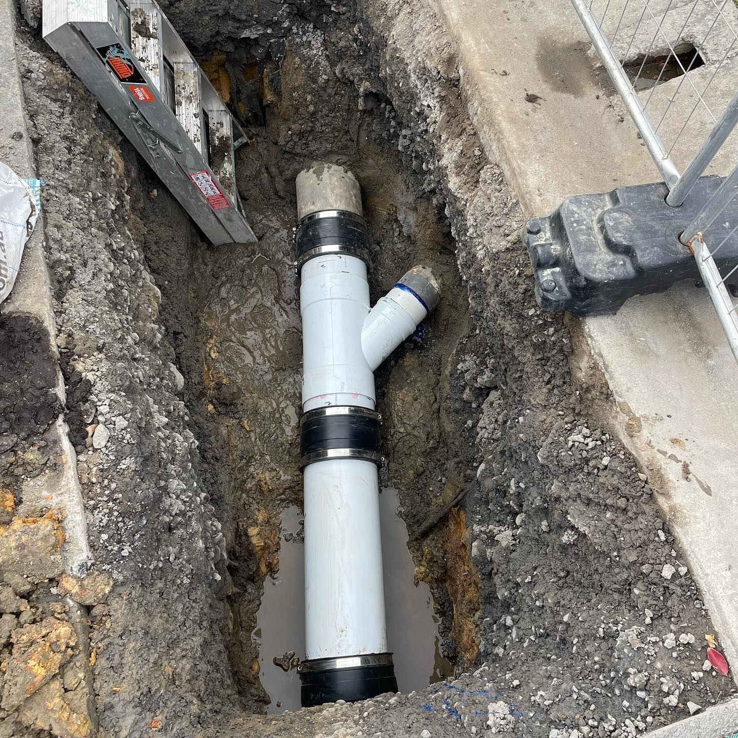 Newly Installed White Pipe Assembly in an Excavated Ditch — Bridge Plumbing & Trades In Huskisson, NSW