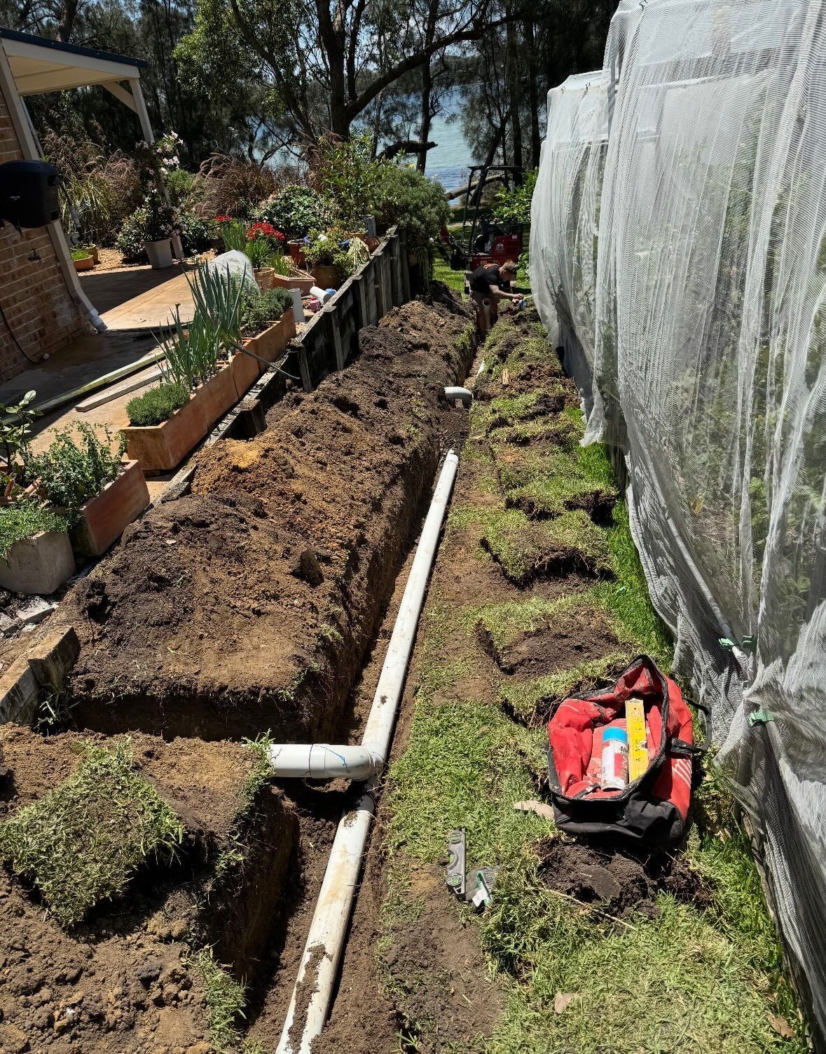 Trench Dug in a Yard, With White Pipes