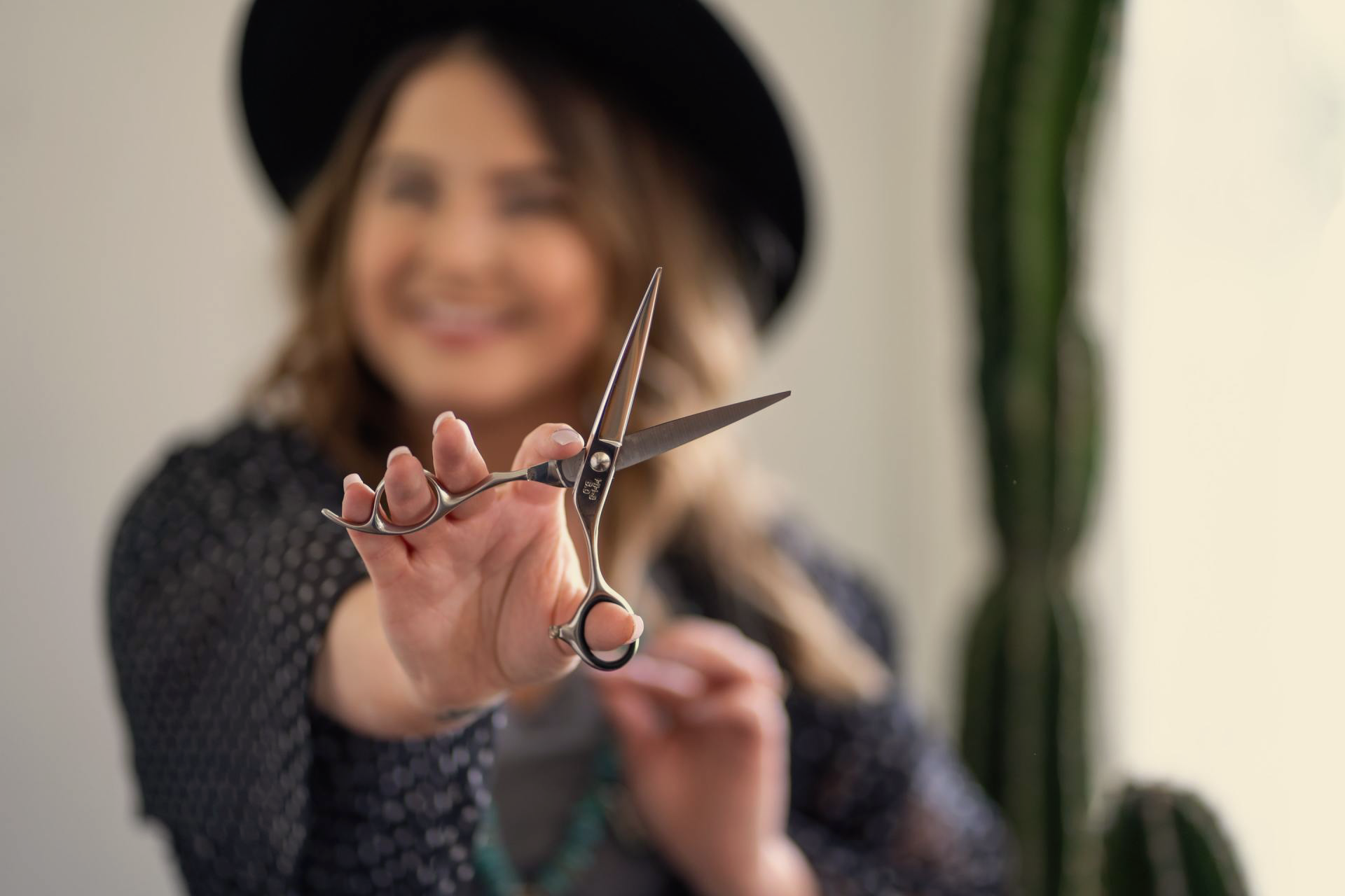 Lady wearing a hat holding a pair of scissors