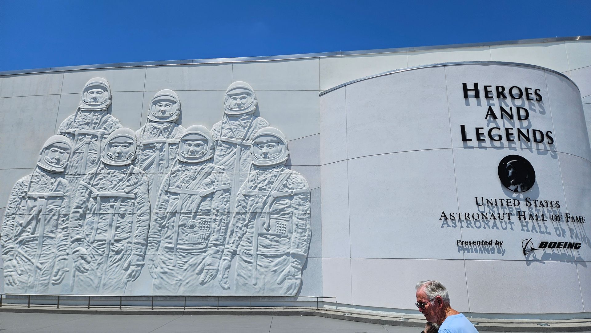 Exterior wall of the U.S. Astronaut Hall of Fame, featuring sculpted astronauts and text 