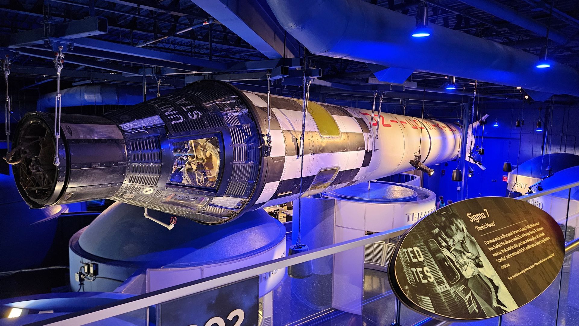 Space capsule exhibit, black and white checkered panels, blue lit museum.