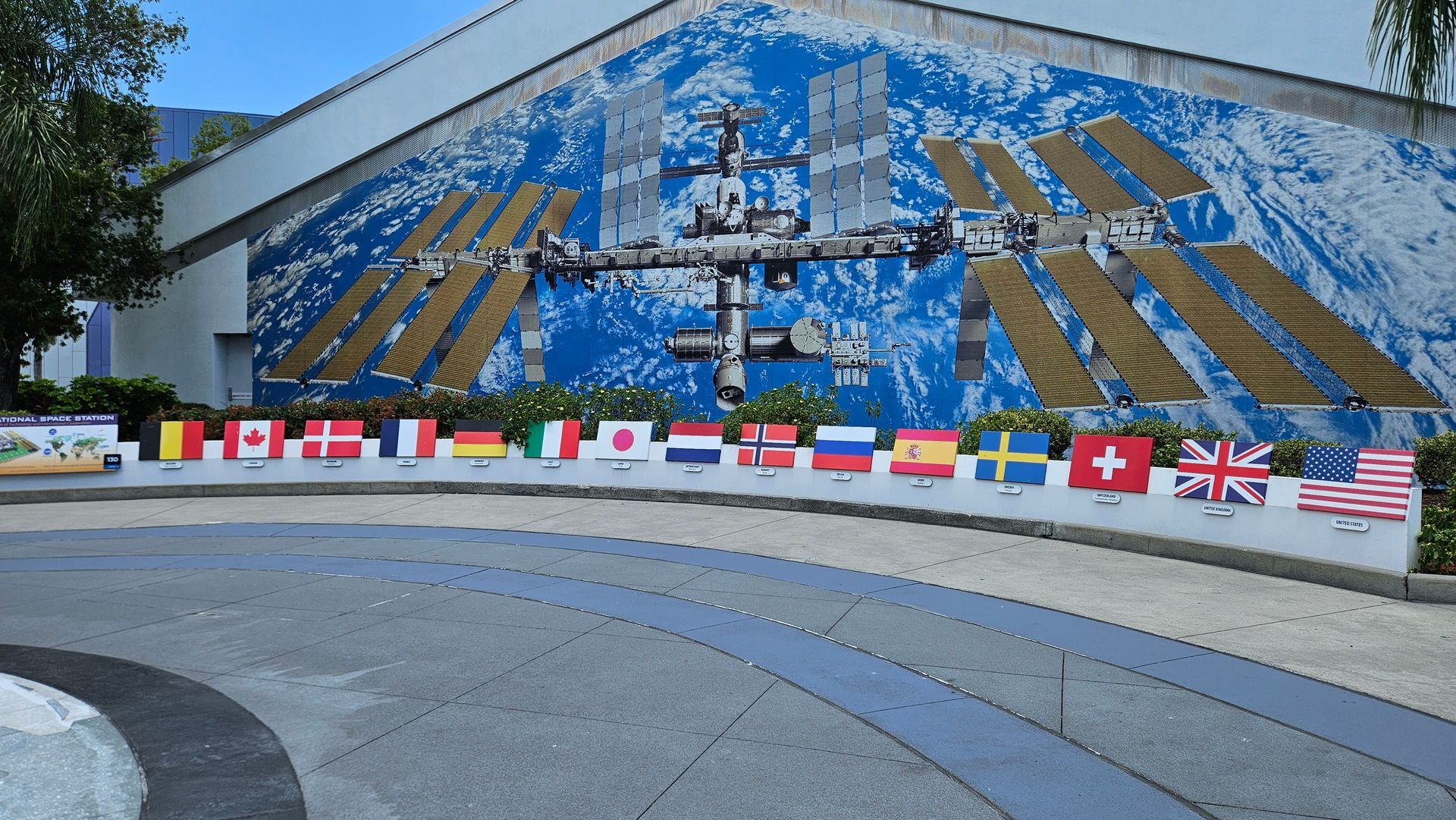 International Space Station mural with flags of participating nations displayed in front.