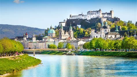 River beside a hilltop fortress and city skyline under a clear blue sky