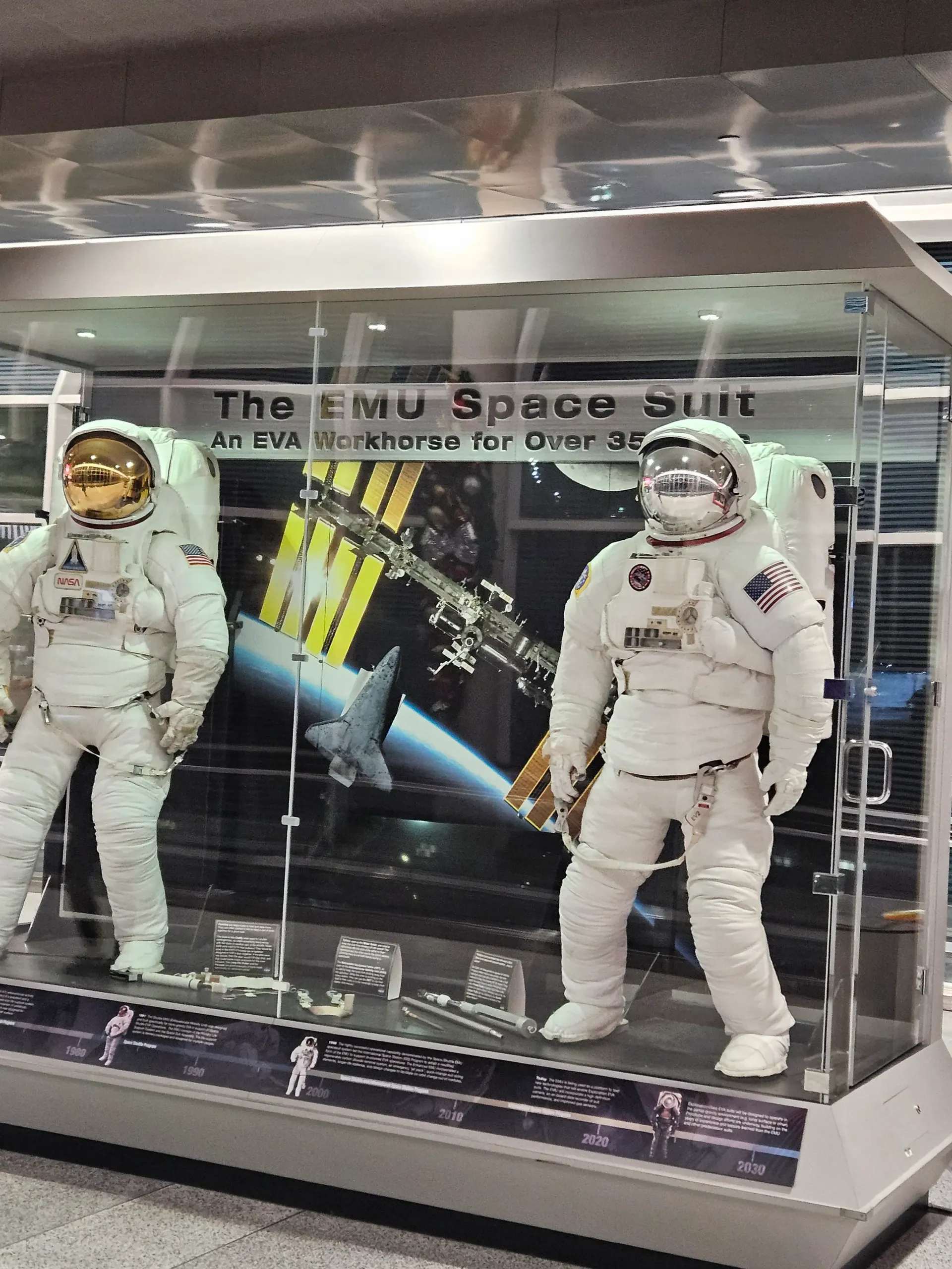 Two astronauts are on display in a glass case