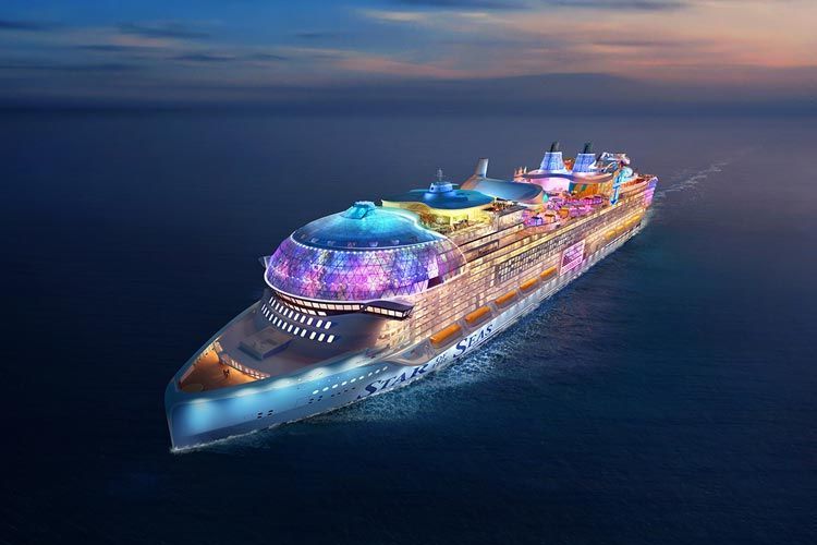 Colorful cruise ship lit up at night on calm dark blue water