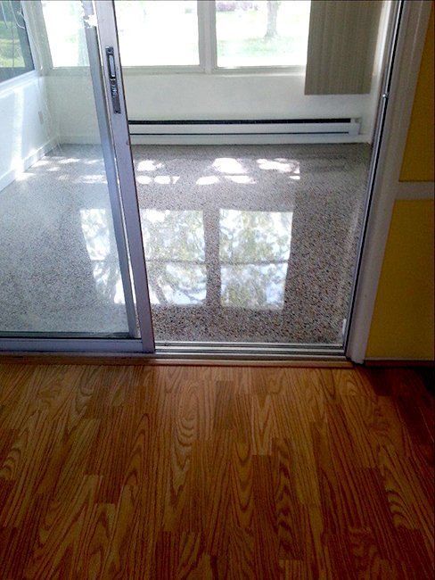 A view through a sliding glass door looking into a sunroom with a glossy.