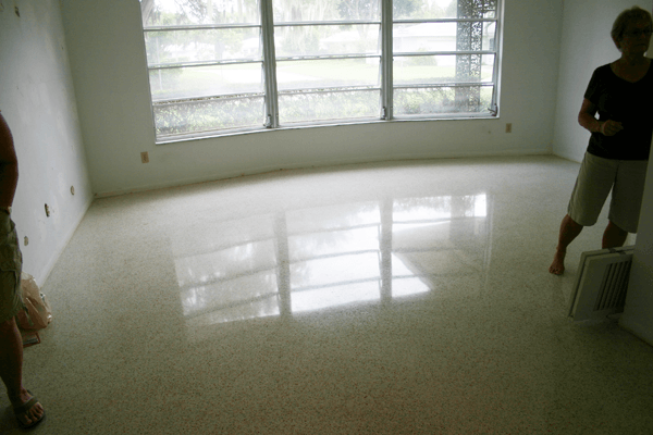An empty room with polished light-colored terrazzo flooring.