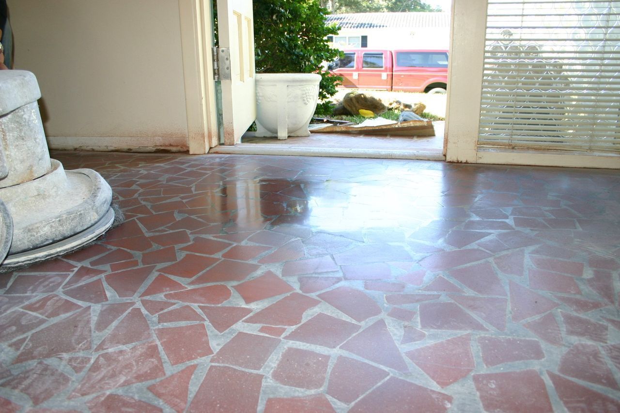 Red flagstone floor with light grout in an entryway.