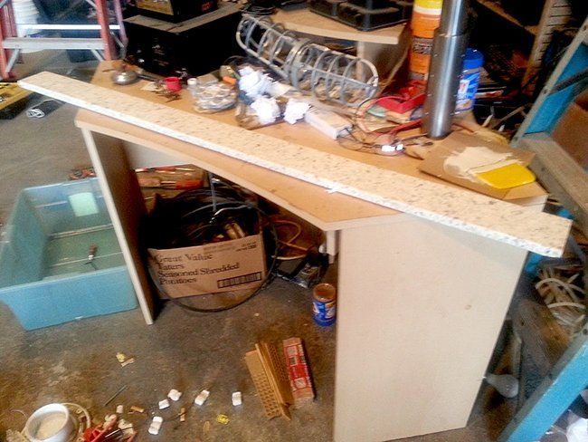 A cluttered garage workspace features a long.