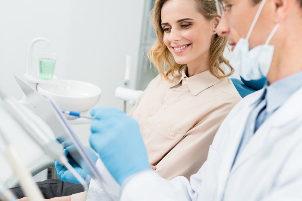 Dentist And Patient Looking At Chart — Island Sands Dental in Boyne Island, QLD