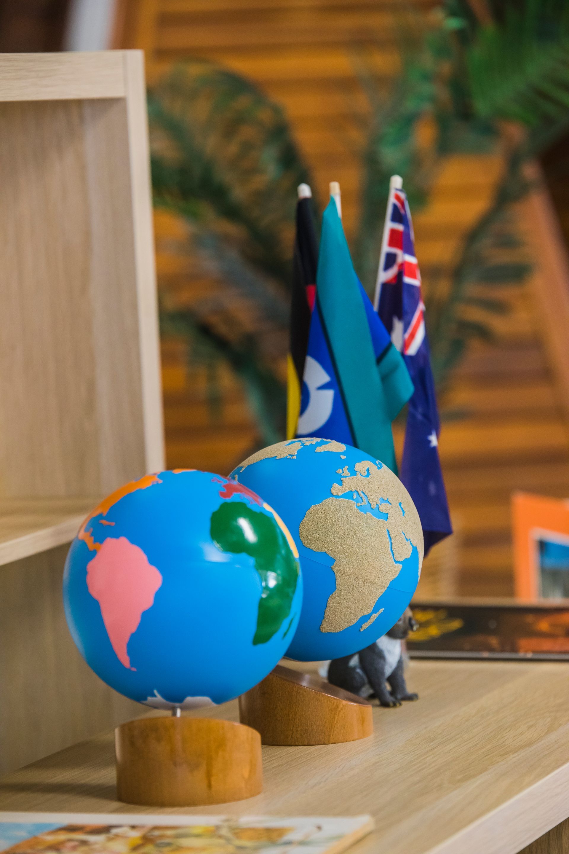 A shelf with a row of globe and flags on it