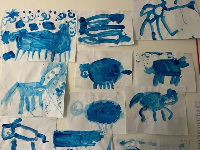 A bunch of blue drawings of animals on a wall