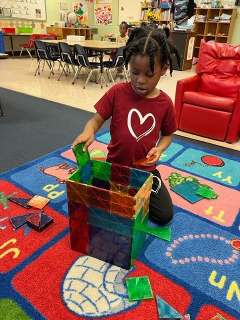 A little girl wearing a red shirt with a heart on it
